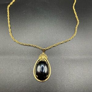 Vintage oval black cabochon pendant necklace with gold-toned metal filigree